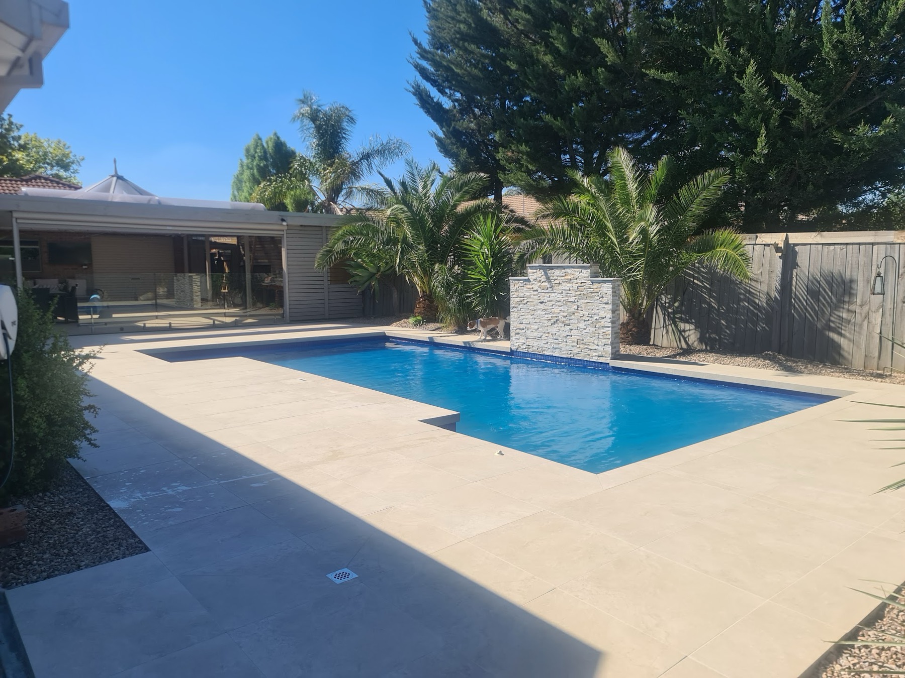 Porcelain pool deck beside a water feature
