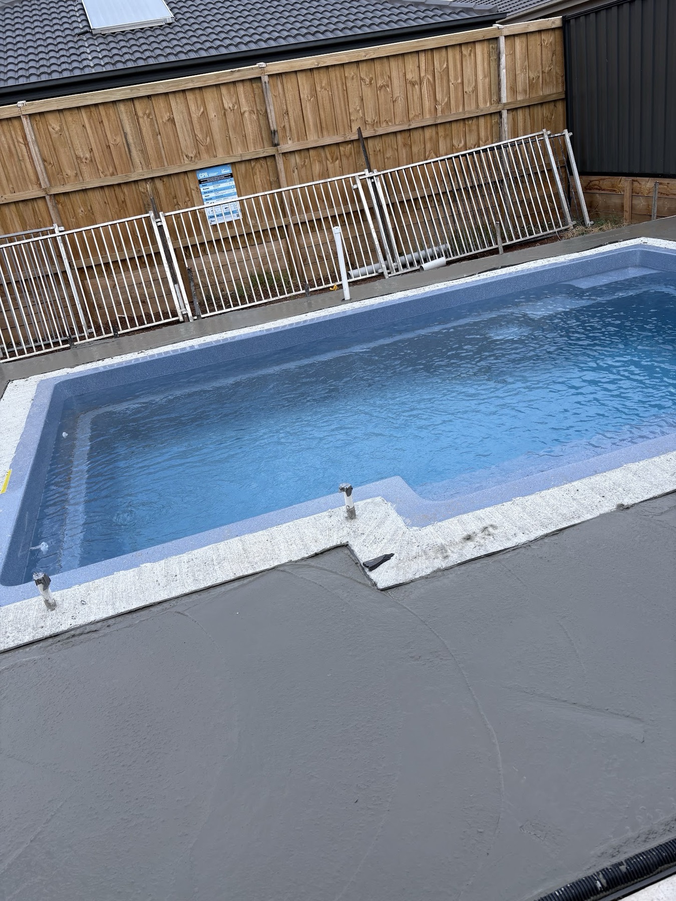 Long view of a turquoise pool and finished surround
