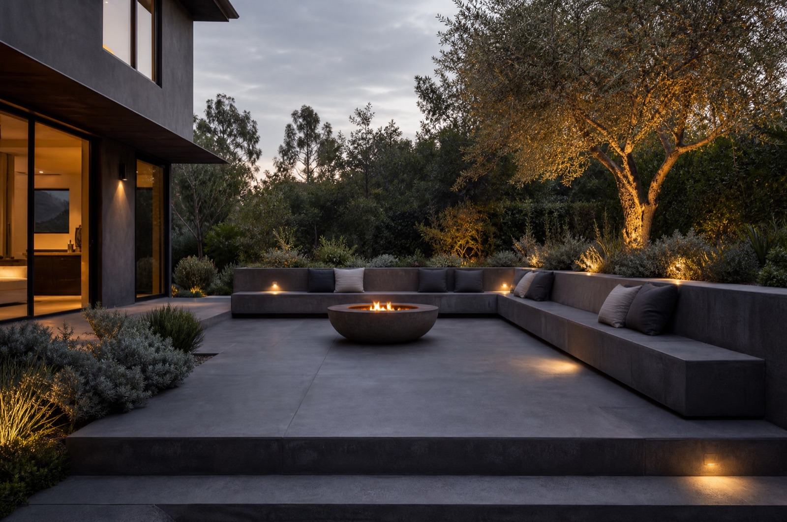 Charcoal polished-concrete terrace with a fire bowl at dusk
